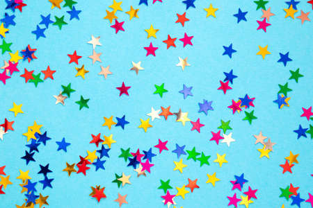 Multicolored stars on a blue paper background. Festive background.の写真素材