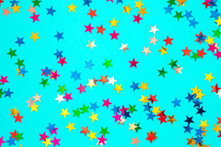 Multicolored stars on a blue paper background. Festive background.の写真素材