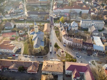 Day view from above on Beregovo. Beautiful top view of the catholic church and procession. Ukraine.