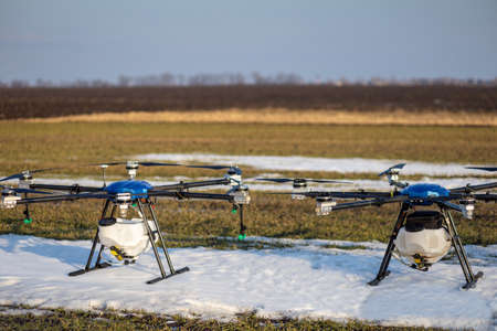 A beautiful blue agrodron stands on the field. Wheat grows. The snow has not melted yet. Agrodrons...