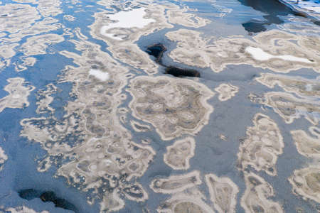 Top view of frozen ice on the river. River in ice. Beautiful snow and frost on the ice.