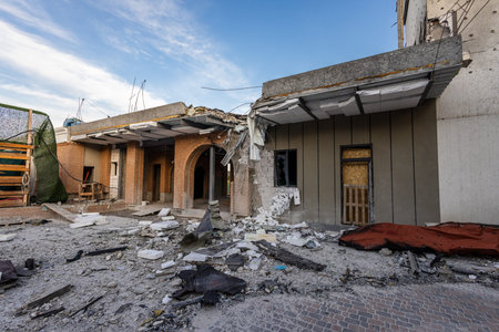 Partially collapsed building with arched brickwork, broken windows, and scattered debris; exposed...