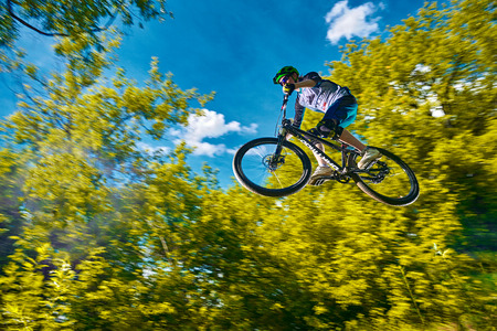 MOSCOW, RUSSIA - JULY 06, 2017: Fly on a mountain bike. Rider in action at mountain bike sport. Biker making a stunt and jumps. Cool athlete cyclist on a bike. MTB biking.のeditorial素材