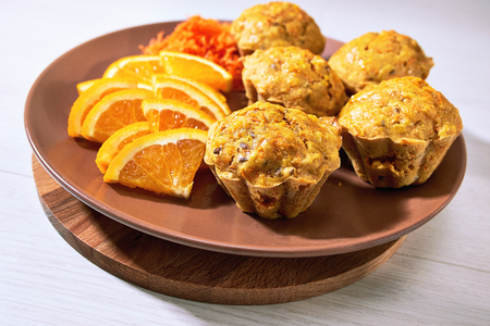 Carotte muffins served on the plate with orange slices.の写真素材
