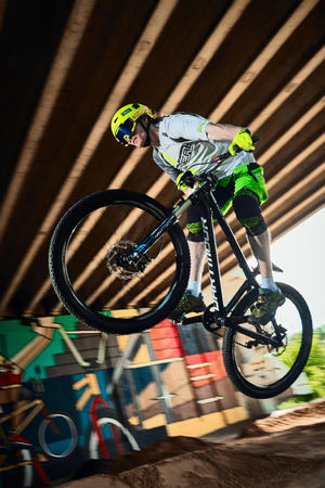 Moscow, Russia - August 8, 2017: Jump and fly on a mountain bike. Rider in action at mountain bike sport. Biker making a stunt and step down jumping. Cool athlete cyclist on a bike. MTB biking.のeditorial素材