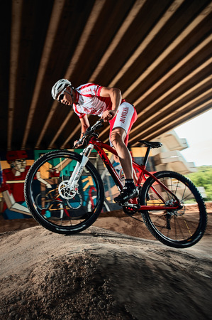 Moscow, Russia - August 10, 2017: Biker riding with aggressive. Mountain Bike cyclist riding pump track. Rider in action at mountain bike sport. Cool athlete cyclist on a bike. MTB biking.のeditorial素材