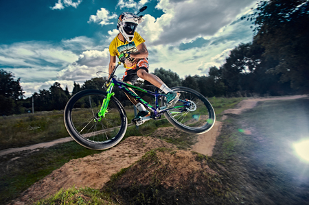 Moscow, Russia - August 9, 2017: Jump and fly on a mountain bike. Rider in action at mountain bike sport. Biker making a stunt and step down jumping. Cool athlete cyclist on a bike. MTB biking.のeditorial素材