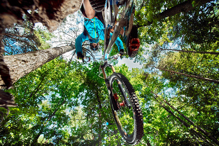 Moscow, Russia - August 18, 2017: Jump and fly on a mountain bike. Rider in action at mountain bike sport. Biker riding in forest. Cool athlete cyclist on a bike. MTB biking.のeditorial素材