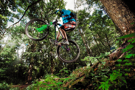 Moscow, Russia - August 18, 2017: Jump and fly on a mountain bike. Rider in action at mountain bike sport. Biker riding in forest. Cool athlete cyclist on a bike. MTB biking.のeditorial素材