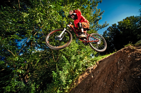Moscow, Russia - August 31, 2017: Jump and fly on a mountain bike. Rider in action at mountain bike sport. Biker riding in forest. Cool athlete cyclist on a bike. MTB biking.のeditorial素材