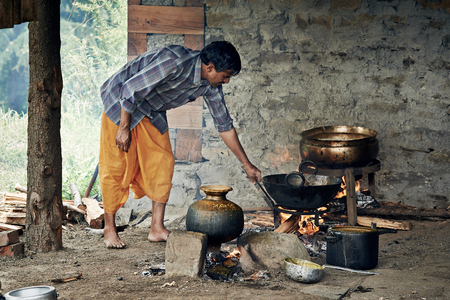 NAGGAR, INDIA - JULY 17: Cooking indian. Hindu man preparing food for a traditional wedding ceremony on July 17, 2013. Naggar, Kullu Valley, Himachal Pradesh, India.のeditorial素材