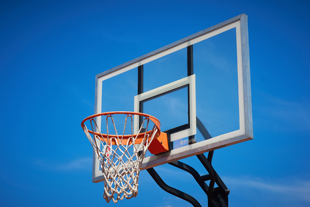 Basketball hoop and backboard with blue sky.の写真素材