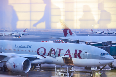 Doha, Qatar - October 2017: Passengers in the Doha Hamad International Airport. Abstract image with half transparent transit passengers going to aircraft.のeditorial素材