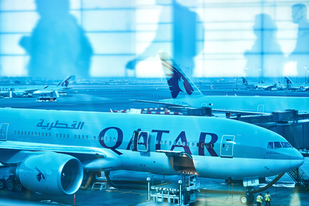 Doha, Qatar - October 2017: Passengers in the Doha Hamad International Airport. Abstract image with half transparent transit passengers going to aircraft.のeditorial素材