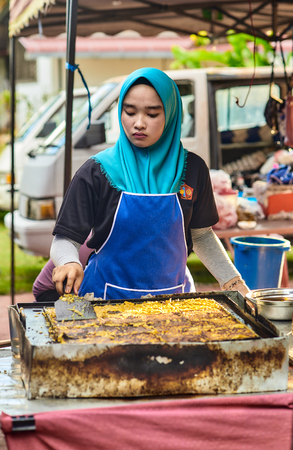 Langkawi, Malaysia â November 2017. Young asian woman cooking of Murtabak â traditional asian cakes with filling inside. Classic asian street food from Langkawi island in Malaysia.のeditorial素材