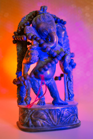 Hindu God - Lord Ganesha with rudraksha rosary in a colorful light. Colorful photo of deity Ganesha whit blured background.の写真素材