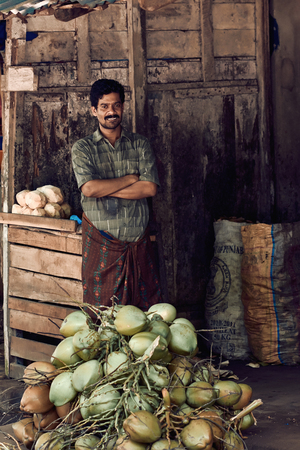 Varkala, Kerala, India â November 30, 2017: Portrait of unidentified Indian man wiht coconats. Daily lifestyle in rural area in South India.のeditorial素材