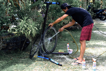 Langkawi, Malaysia - November 14, 2018: Asian man are washing road bicycle near by home. Preparing bicycle for triathlon race.のeditorial素材