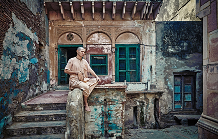 Vrindavan, India - JULY 17: Yogi man sits near the temple of Krishna. Repeats the secret mantra using a rosary. Chanting 108 sacred name of God. July 17, 2013 in Vrindavan, Uttar Pradesh, India.のeditorial素材