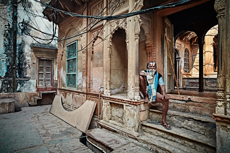 Vrindavan, India - JULY 17: Yogi man sits near the temple of Krishna. Repeats the secret mantra using a rosary. Chanting 108 sacred name of God. July 17, 2013 in Vrindavan, Uttar Pradesh, India.のeditorial素材