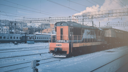 Moscow, Russia - Jan 2019: Locomotive russian RZD cargo company at the head of the freight train. Locomotive carries freight train past the railway station, the concept of transportation.のeditorial素材