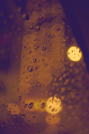 Abstract circular bokeh background of night light with raindropsの写真素材