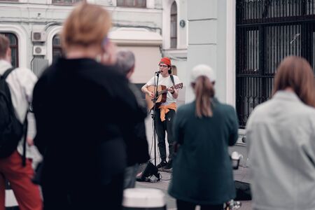 Moscow, Russia - Aug 28, 2019: Man playing guitar on the street outdoor. Young musician artist...