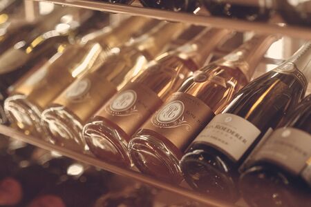 Paris, France - Dec 2019: Mood shot of brut Champagne sparkling wine Louis Roederer Cristal Rose 2009 and other wines in rack in restaurant. Close up wine bottles. Wine par excellence with a finesse.のeditorial素材