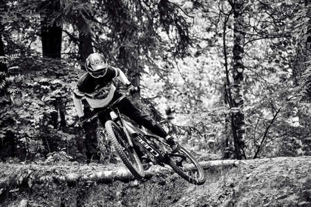 Russia, Moscow - Sep 01, 2020: Young boy jumping with his MTB Bike at forest. Professional downhill...