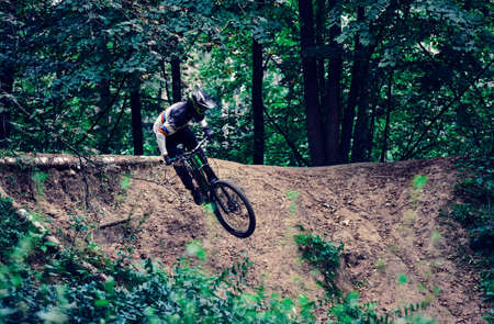 Russia, Moscow - Sep 01, 2020: Young boy jumping with his MTB Bike at forest. Professional downhill...
