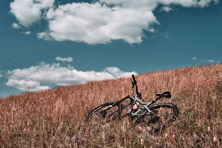 Russia, Moscow - Sep 2020: Mountain bike in wild nature landscape background. Panoramic landscape of central Russia agricultural countryside with hillのeditorial素材