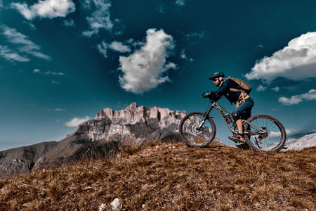 Elbrus, Kabardino-Balkaria, Russia - Sep 2021: Mountain biking in Elbrus. Cyclist on the top of a hill and enjoying view of the mountains. MTB bicycle rider standing at cliff.のeditorial素材