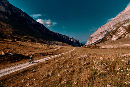 Mans with bicycles riding on country road in the mountains. Mountain biking in the mountains.の写真素材