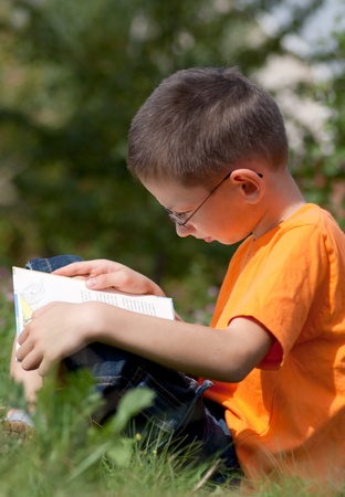 Boy reading a book on a summer dayの写真素材