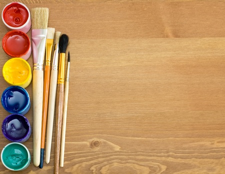 paints and brushes on wooden table の写真素材