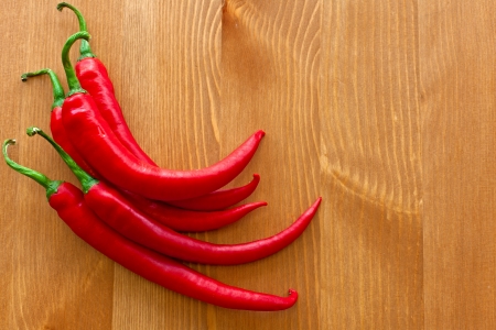 hot red peppers on wooden tableの写真素材