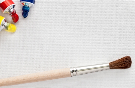 White canvas texture with paints and paintbrushの写真素材