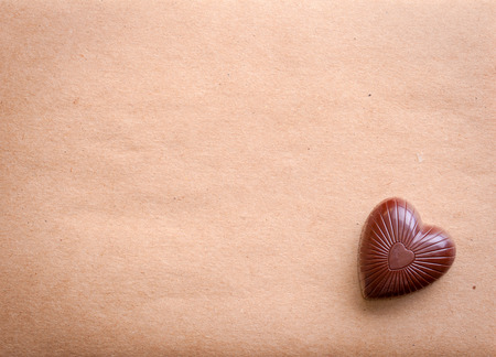 Chocolate heart over old paperの写真素材