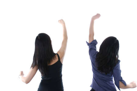 Two girls with their hands up isolated over whiteの写真素材