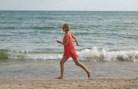 Young woman running on the beachの写真素材
