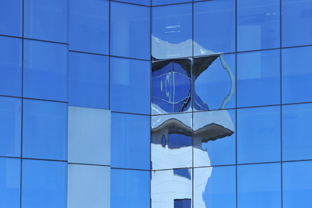 Reflections on a blue glass panel of a Glass wall building
