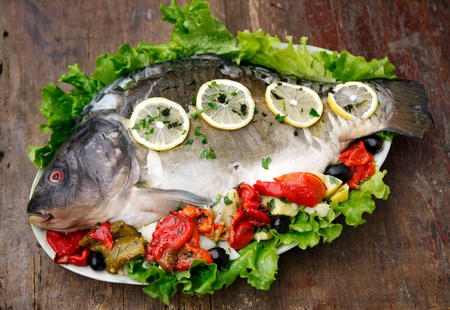 Carp with potato and vegetable isolated on wooden backgroundの写真素材