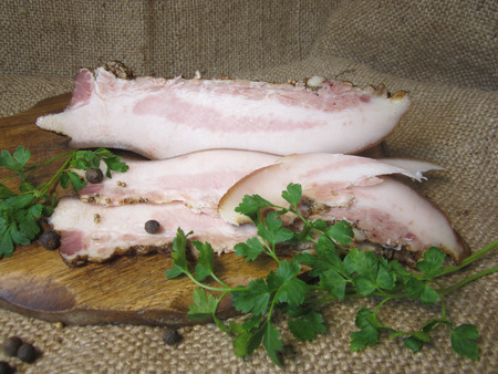 slices of smoked bacon with parsley and spicesの写真素材
