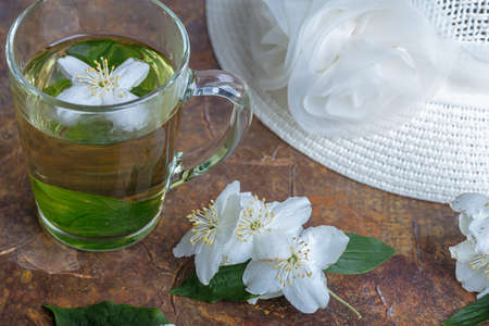 Summer hat, jasmine tea in a mug, flowers. Still life. High quality photoの写真素材