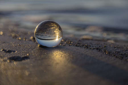 Beautiful sunrise captured through a lens ball on a beach. Finland. Gulf of Finland. . High quality photoの写真素材