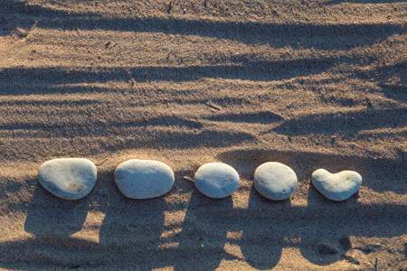 Lined smooth pebbles in the sand, Copy space . High quality photoの写真素材