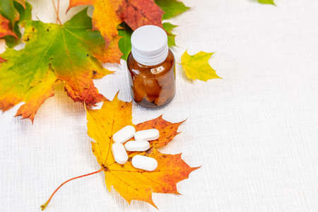 Still life on a white background maple leaves, glass bottle and pills, concept, take care of autumn, health. High quality photoの写真素材