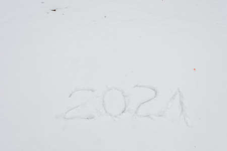 It says 2021 in the snow, Close-up. New Years coming soon concept. Natural background, There is a...