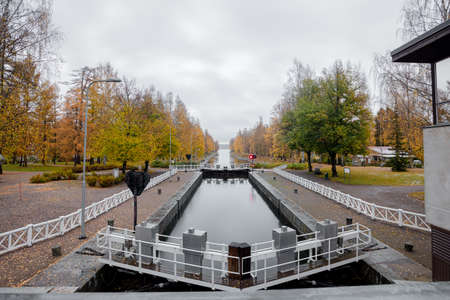 View of the canal, in autumn, yellow birches on the bank and reflection in the water. Its a nasty day . High quality photoの写真素材