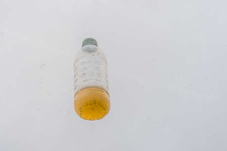 Plastic bottle with yellow liquid. The concept of abandoned trash, cleaning. High quality photo